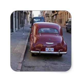 A classic old red Peugeot car parked on a street Square Sticker