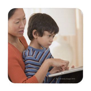 Asian mother and son using laptop drink coasters