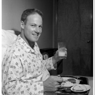 Mid adult man having breakfast in bed Poster Print (18 x 24)